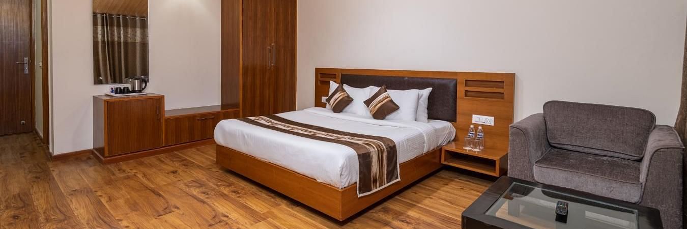 Image of a room with king size bed, side table and a cupboard